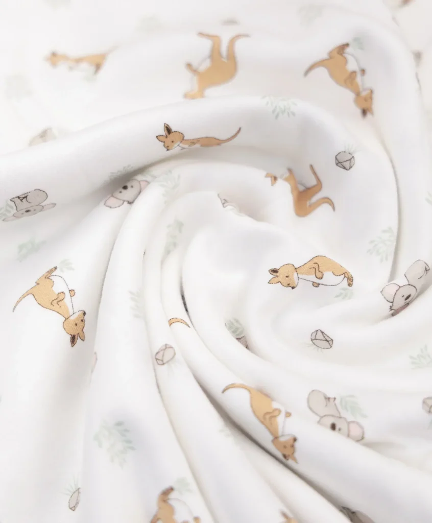 Organic cotton baby swaddle wrap with kangaroo and koala print, draped to show soft fabric texture