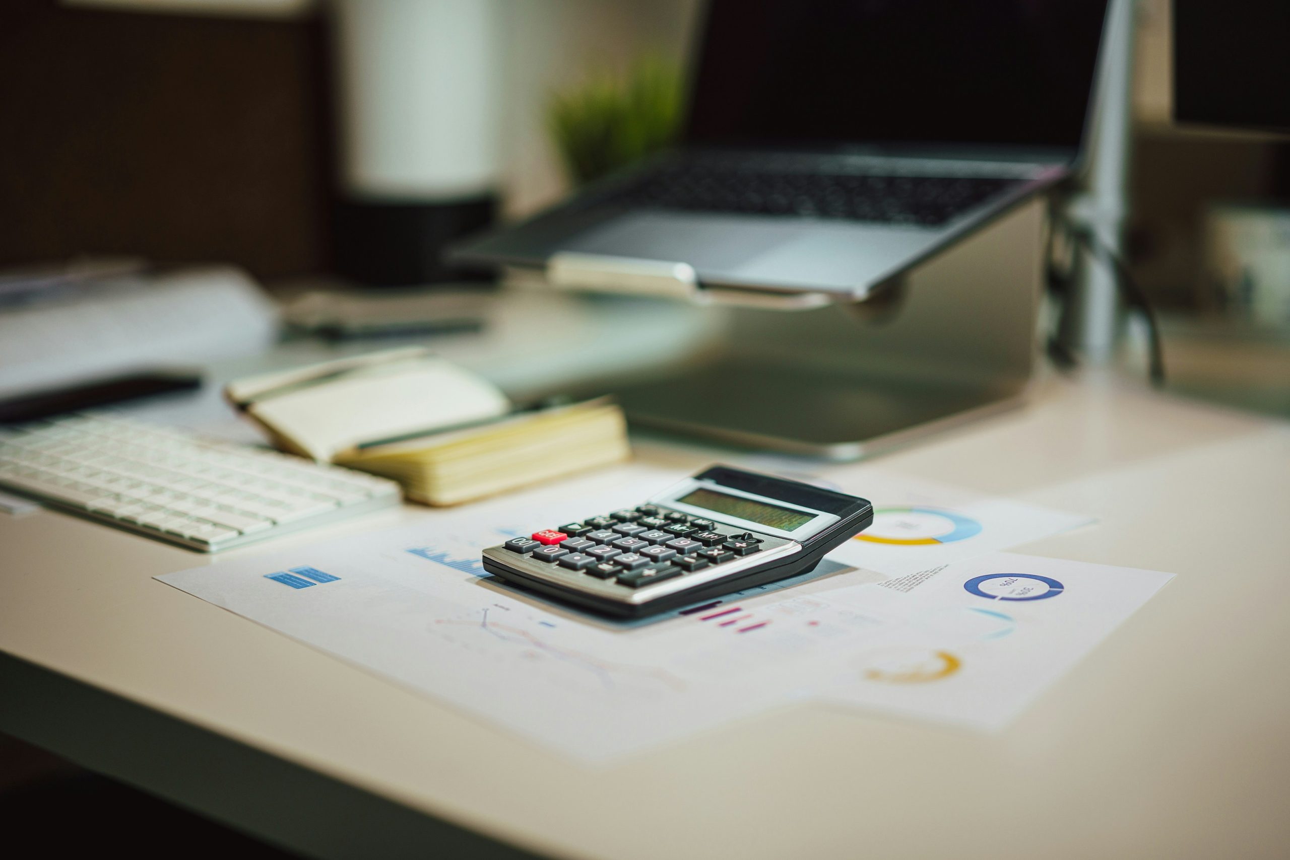 Retirement planning documents, charts, and a calculator on a wooden table