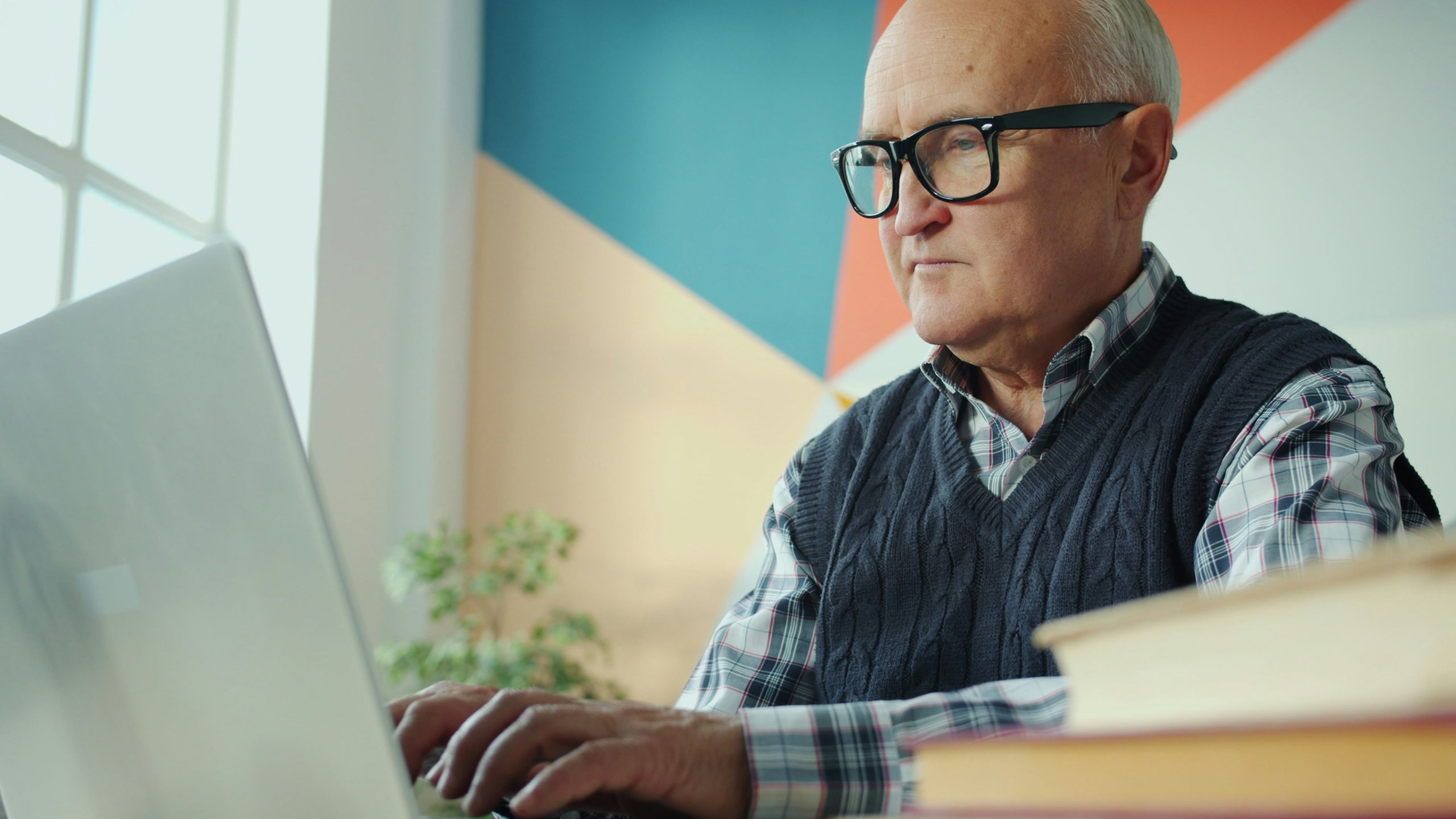 Older business owner reviewing retirement and pension paperwork at a desk